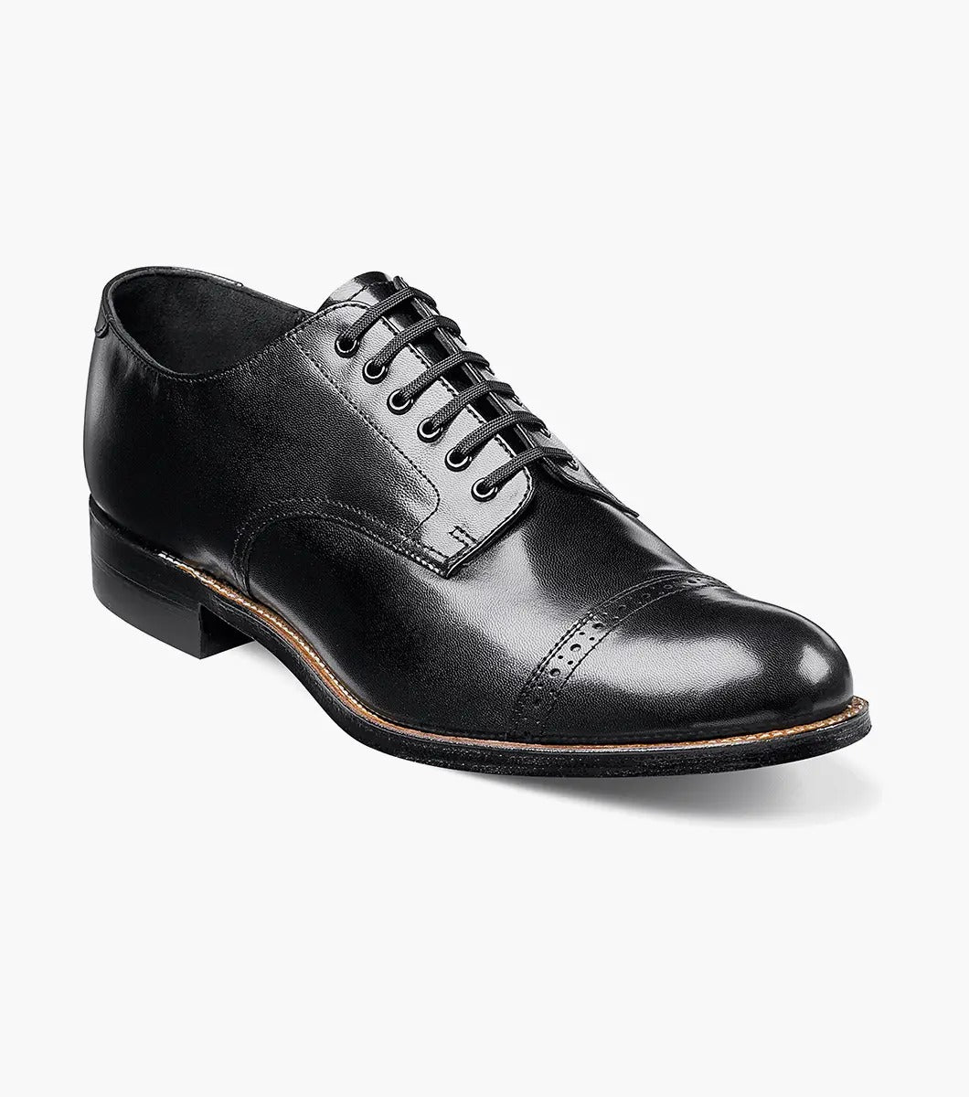 The Stacy Adams MADISON Cap Toe Oxford in black (product code: 00012-01) is a kidskin leather shoe with laces, presented against a pristine white background, and it boasts impeccable Goodyear welt construction for both durability and style.