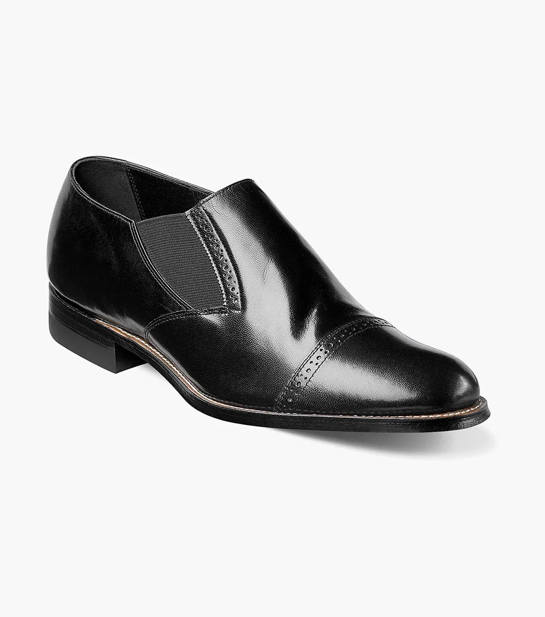 Introducing the Stacy Adams - MADISON Cap Toe Slip On, a sleek black kidskin leather dress shoe with a cap toe design and elastic side panels, presented against a white backdrop.