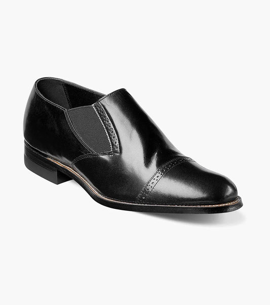 Introducing the Stacy Adams - MADISON Cap Toe Slip On, a sleek black kidskin leather dress shoe with a cap toe design and elastic side panels, presented against a white backdrop.