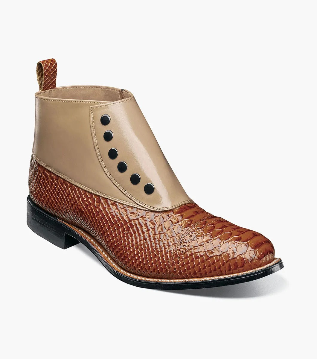 The Stacy Adams MADISON Spectator Spat Cap Toe Demi Boot in Tan Multi showcases a sophisticated design with a smooth kidskin leather upper, textured lower, and black side buttons, complemented by a genuine leather sole for timeless elegance.