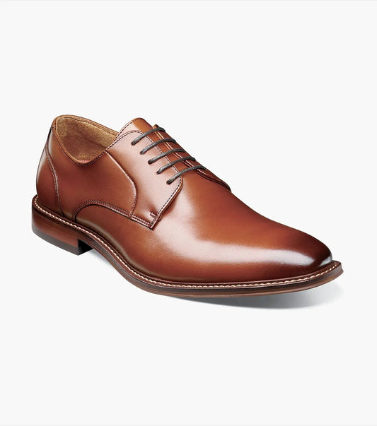 The Stacy Adams MARLTON Plain Toe Oxford in cognac, model 25490-221, is showcased from the side on a white background. This single lace-up dress shoe features brown burnished leather and includes a RedZone insole for enhanced comfort.