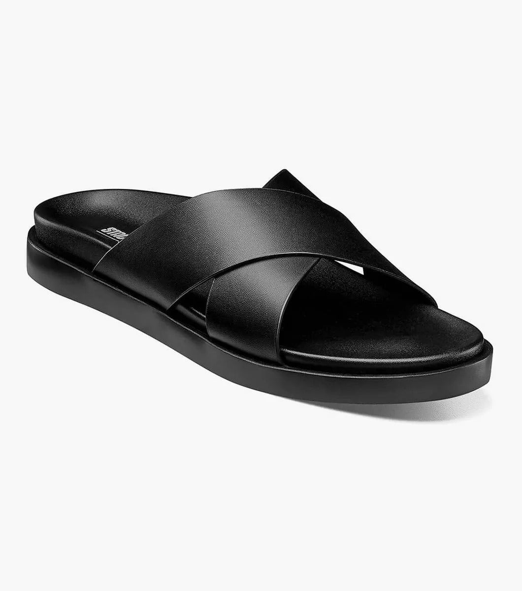 The STACY ADAMS - MONTEL Cross Strap Slide Sandal in Black (Product Number: 25469-001) showcases a sleek design featuring crisscross straps and a comfortable flat sole, complete with a cushioned insole for all-day support.