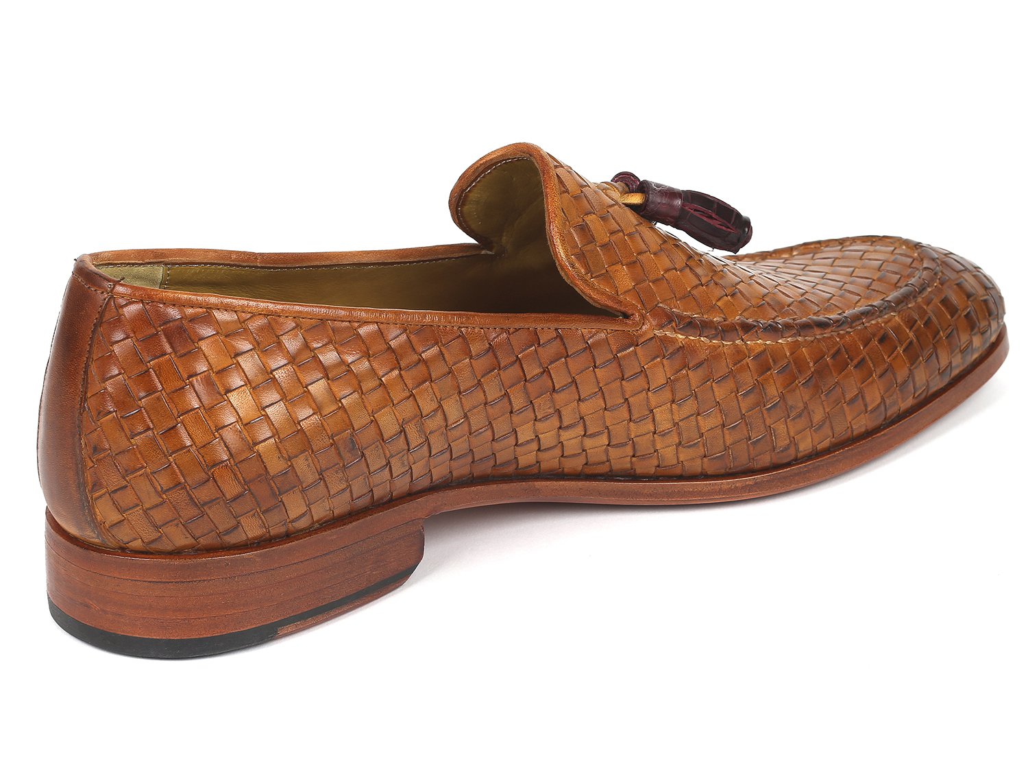 The Paul Parkman Woven Leather Tassel Loafers Camel - WVN44-CML, crafted by Paul Parkman, are men's shoes made from woven leather featuring elegant tassels and low wooden heels. Viewed from the top and side, these loafers embody a blend of style and comfort.