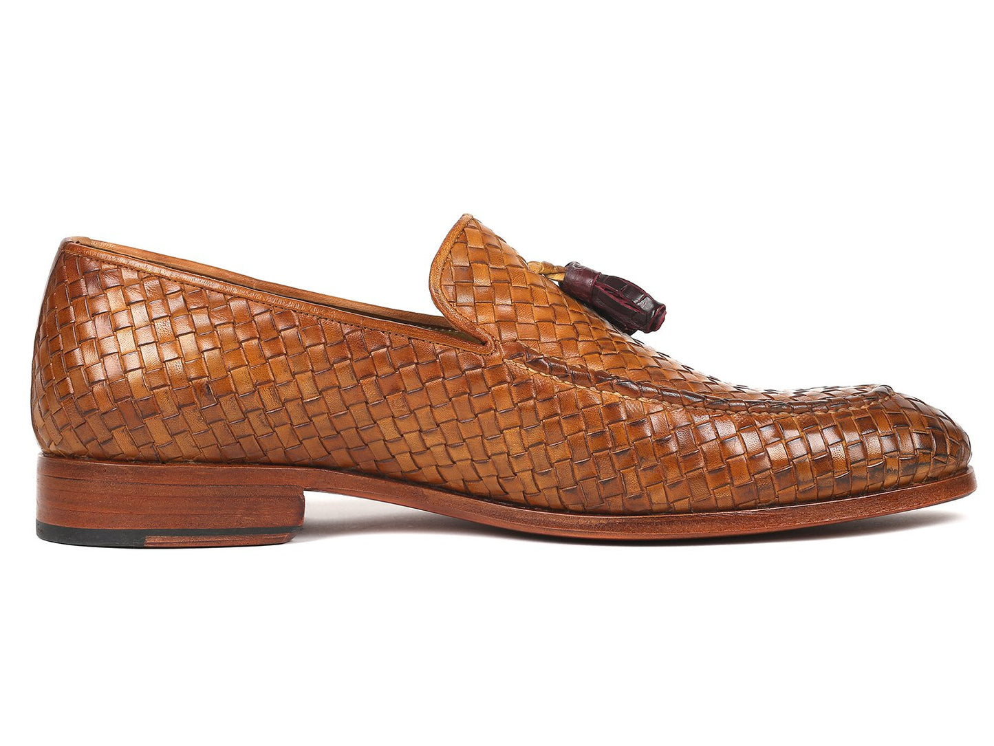 The Paul Parkman Woven Leather Tassel Loafers Camel - WVN44-CML, crafted by Paul Parkman, are men's shoes made from woven leather featuring elegant tassels and low wooden heels. Viewed from the top and side, these loafers embody a blend of style and comfort.