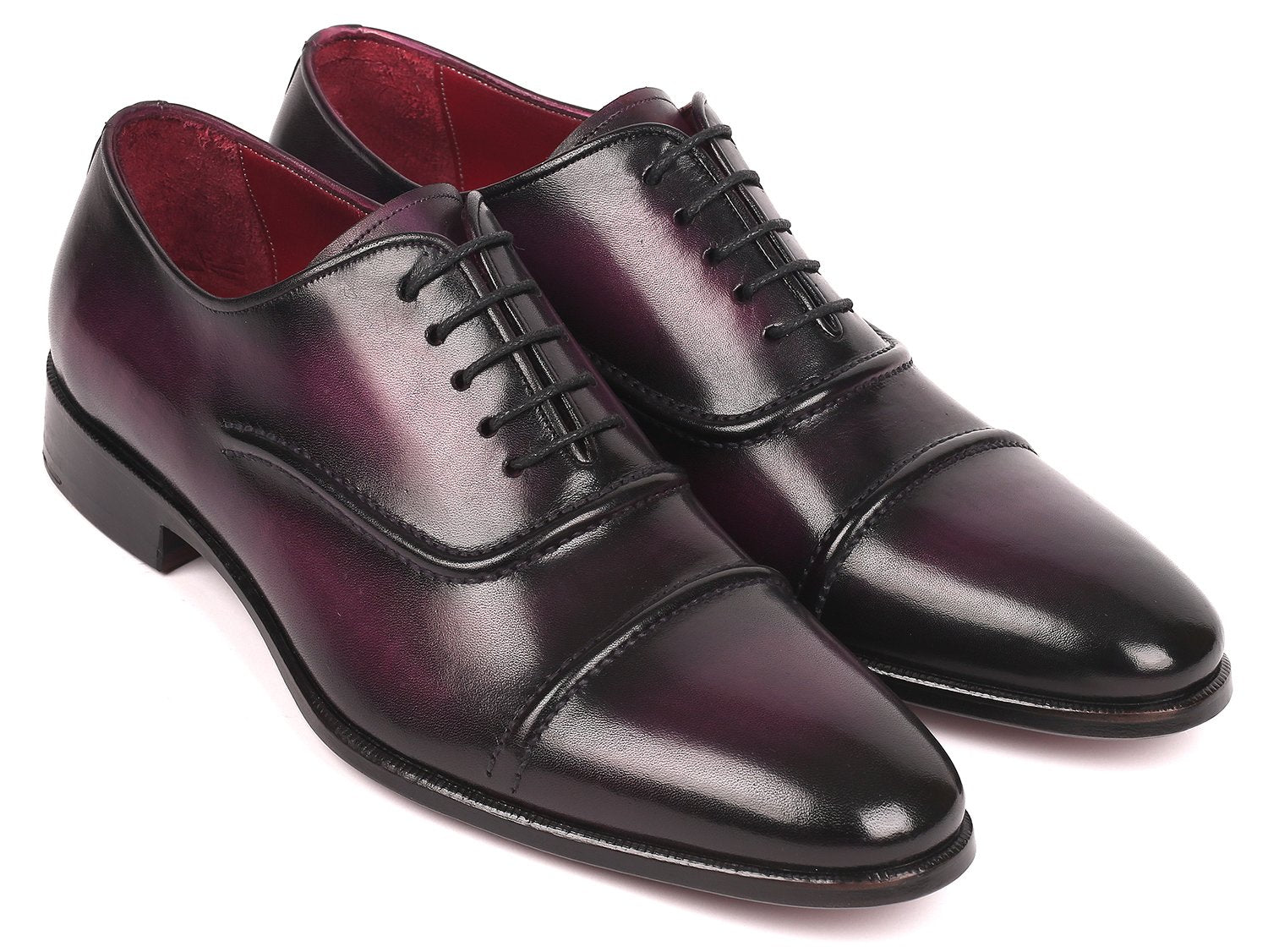 A pair of Paul Parkman Captoe Oxfords in a rich purple hue, featuring a polished handmade leather finish with black laces and a classic captoe design, is arranged diagonally on a white background.