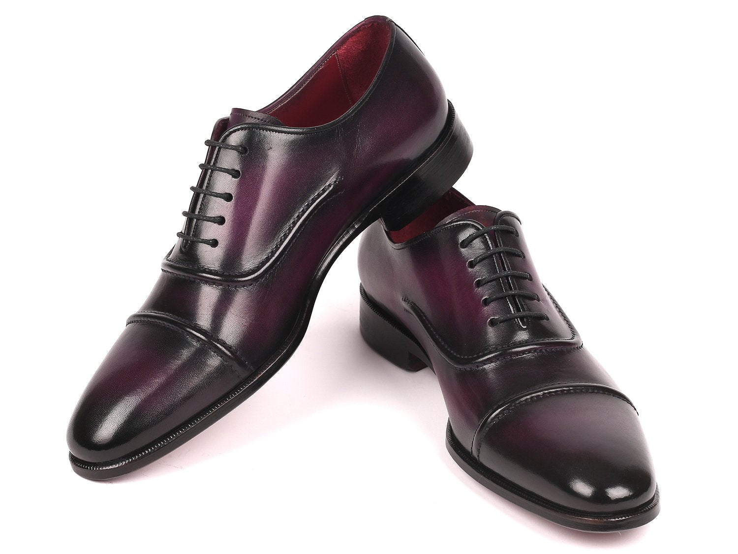 A pair of Paul Parkman Captoe Oxfords in a rich purple hue, featuring a polished handmade leather finish with black laces and a classic captoe design, is arranged diagonally on a white background.