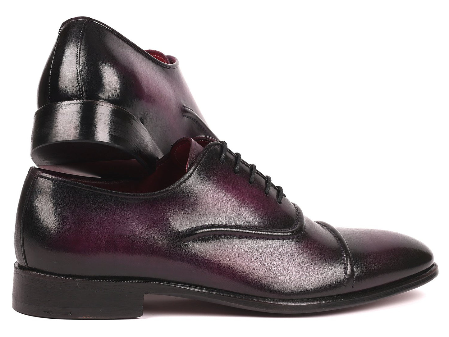 The Paul Parkman Captoe Oxfords in a rich purple hue, featuring handmade craftsmanship with black cap toes and laces, are elegantly displayed on a pristine white background.