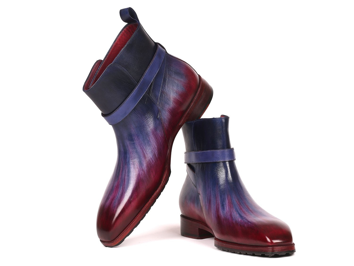 Introducing the Paul Parkman Multicolor Patina Jodhpur Boots - 955MIX32, these boots have a stylish design featuring multi-toned purple and burgundy leather with a low heel. One boot stands upright while the other leans against it, elegantly displaying its craftsmanship.