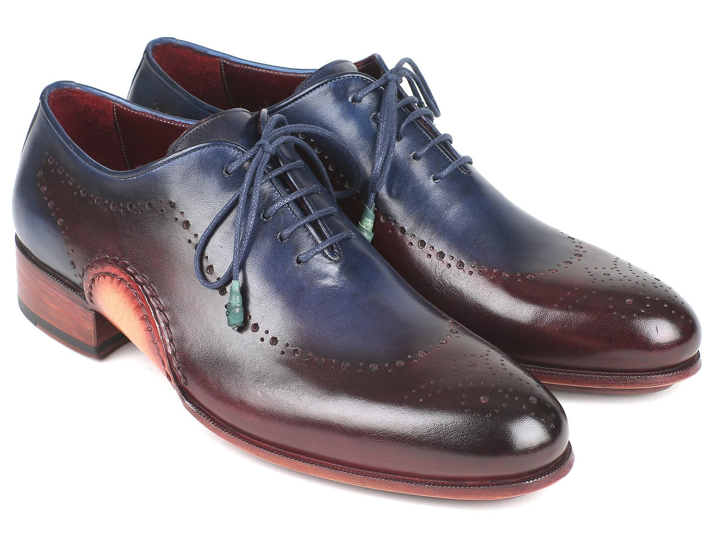 The Paul Parkman Opanka Construction Blue & Bordeaux Oxfords - 726-BLU-BRD are hand-painted leather dress shoes with decorative perforations and laces, elegantly displayed against a white backdrop. These made-to-order shoes combine style and durability through their unique Opanka construction.