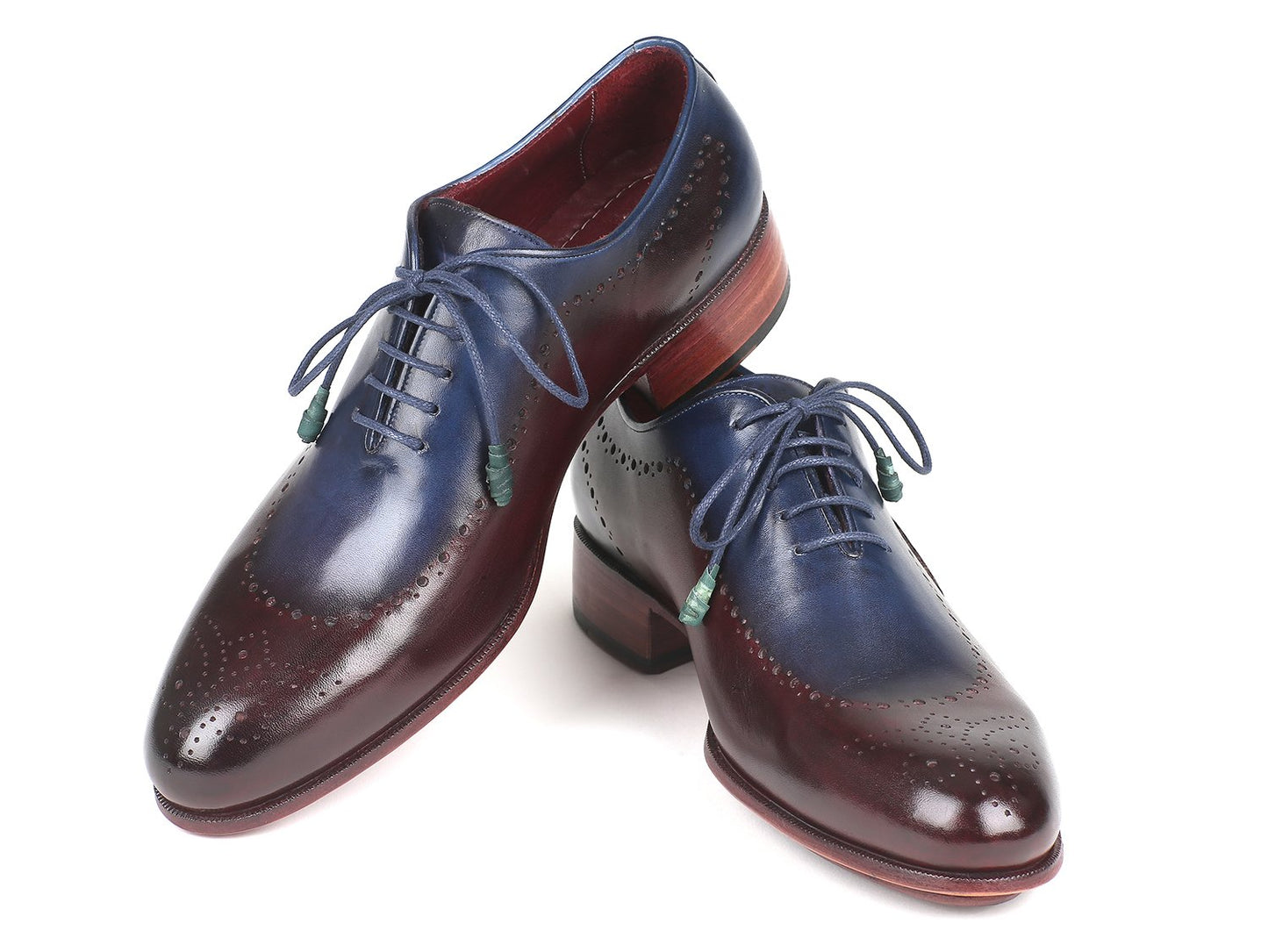 The Paul Parkman Opanka Construction Blue & Bordeaux Oxfords - 726-BLU-BRD are hand-painted leather dress shoes with decorative perforations and laces, elegantly displayed against a white backdrop. These made-to-order shoes combine style and durability through their unique Opanka construction.