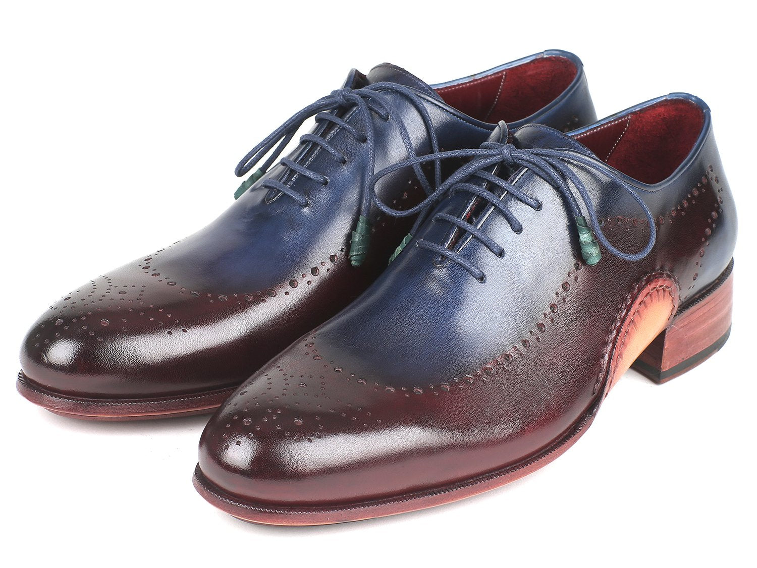 The Paul Parkman Opanka Construction Blue & Bordeaux Oxfords - 726-BLU-BRD are hand-painted leather dress shoes with decorative perforations and laces, elegantly displayed against a white backdrop. These made-to-order shoes combine style and durability through their unique Opanka construction.