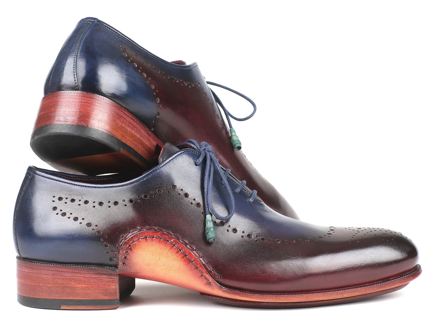 The Paul Parkman Opanka Construction Blue & Bordeaux Oxfords - 726-BLU-BRD are hand-painted leather dress shoes with decorative perforations and laces, elegantly displayed against a white backdrop. These made-to-order shoes combine style and durability through their unique Opanka construction.