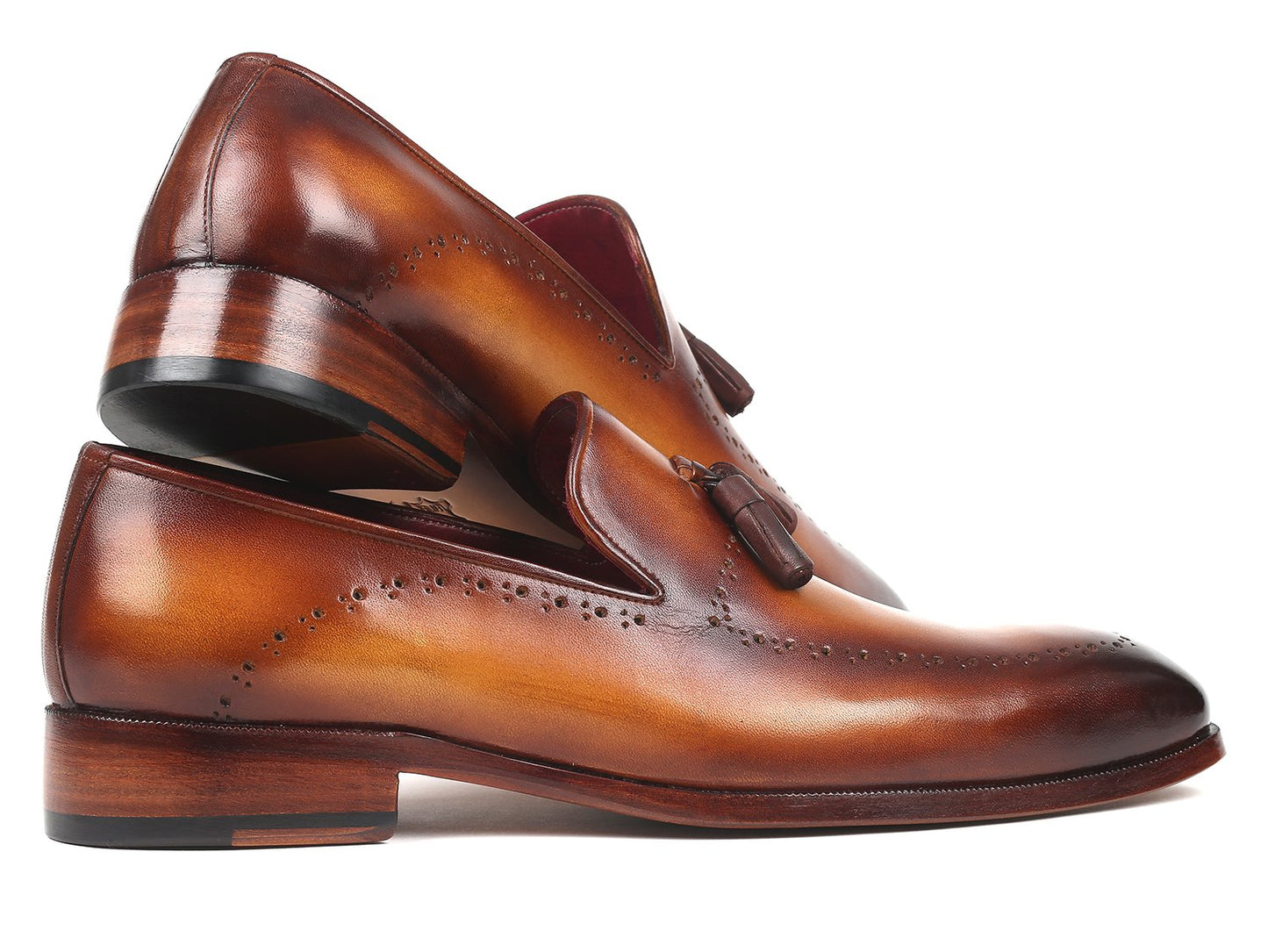 The Paul Parkman Tassel Loafer Brown - 66T81-BRW showcases hand-painted finesse and decorative perforations arranged in a crossed position on a pristine white background.