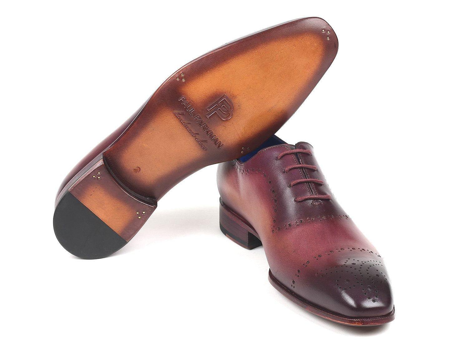 A pair of Paul Parkman Burgundy Hand-Painted Classic Brogues - ZLS35BUR, featuring a men's burgundy leather design with perforated details, hand-painted calfskin, and a blue interior lining, placed on a white background.