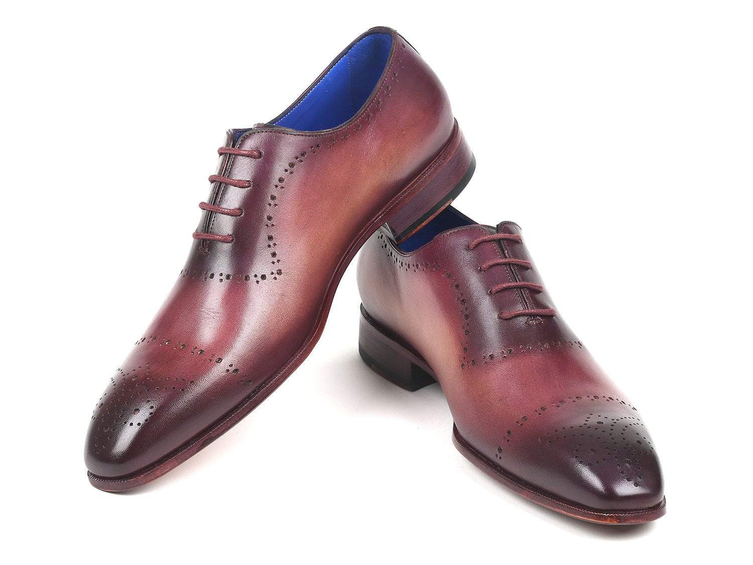 A pair of Paul Parkman Burgundy Hand-Painted Classic Brogues - ZLS35BUR, featuring a men's burgundy leather design with perforated details, hand-painted calfskin, and a blue interior lining, placed on a white background.