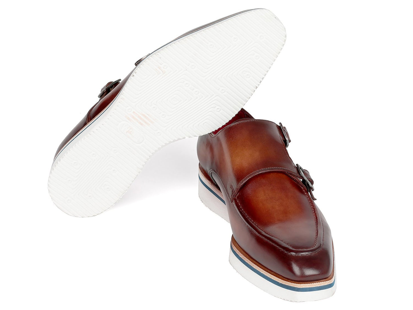 The Paul Parkman Smart Casual Monkstrap Shoes in brown leather feature a crisscross buckle design and white soles, embodying a smart casual style.