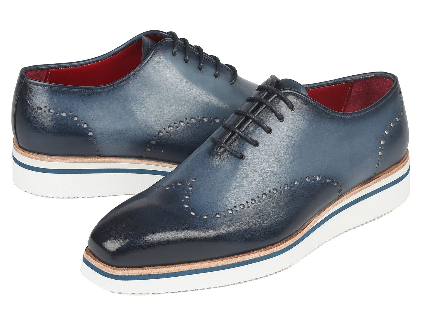 The Paul Parkman Smart Casual Wingtip Oxfords Navy - 187-NAVY are a pair of navy leather shoes with white soles, featuring decorative perforations and stitches. These stylish shoes from Paul Parkman, placed on a white background, embody style and versatility, making them perfect for any occasion.