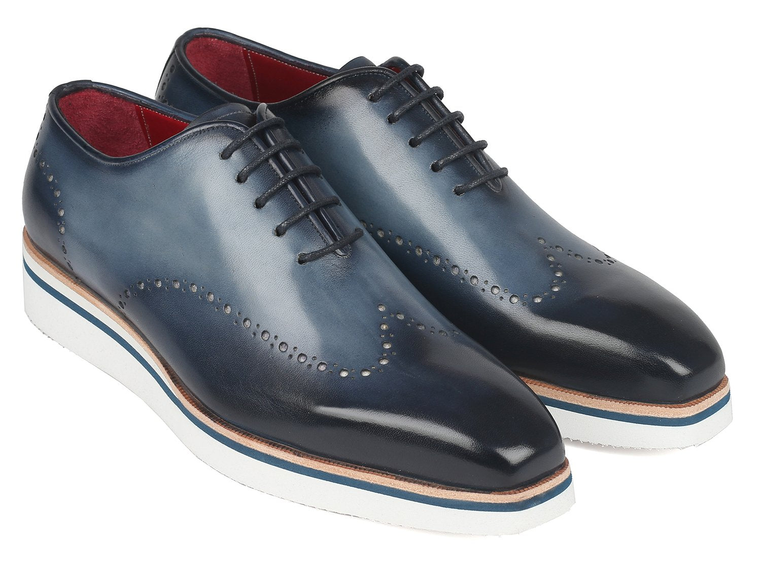 The Paul Parkman Smart Casual Wingtip Oxfords Navy - 187-NAVY are a pair of navy leather shoes with white soles, featuring decorative perforations and stitches. These stylish shoes from Paul Parkman, placed on a white background, embody style and versatility, making them perfect for any occasion.