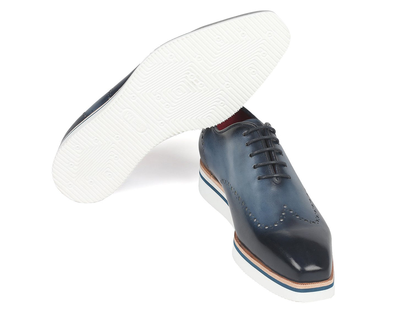 The Paul Parkman Smart Casual Wingtip Oxfords Navy - 187-NAVY are a pair of navy leather shoes with white soles, featuring decorative perforations and stitches. These stylish shoes from Paul Parkman, placed on a white background, embody style and versatility, making them perfect for any occasion.