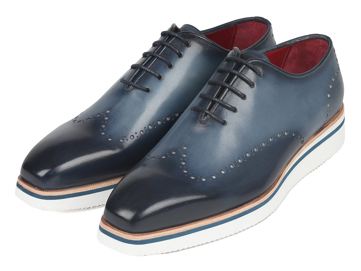 The Paul Parkman Smart Casual Wingtip Oxfords Navy - 187-NAVY are a pair of navy leather shoes with white soles, featuring decorative perforations and stitches. These stylish shoes from Paul Parkman, placed on a white background, embody style and versatility, making them perfect for any occasion.