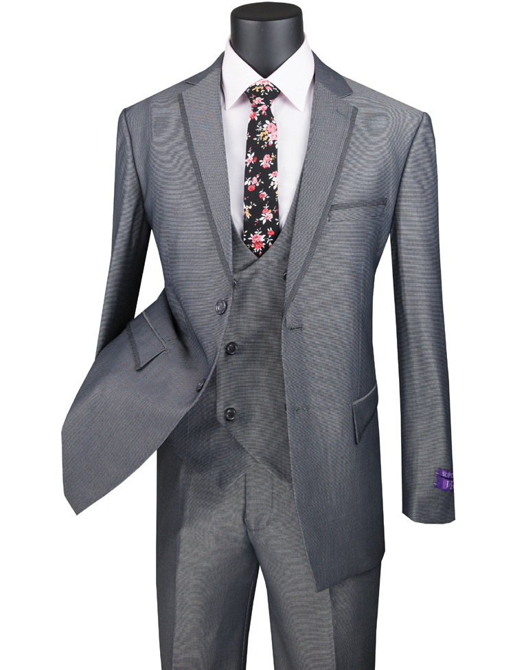 A Vinci Modern Fit 3 Piece Suit with a Birdseye Pattern and Contrast Trim in charcoal is showcased on a mannequin. The ensemble includes a white shirt and a black floral tie, with the sleek design of Vinci Suits elegantly accentuating its modern trim—ideal for those looking to combine sophistication with contemporary style.