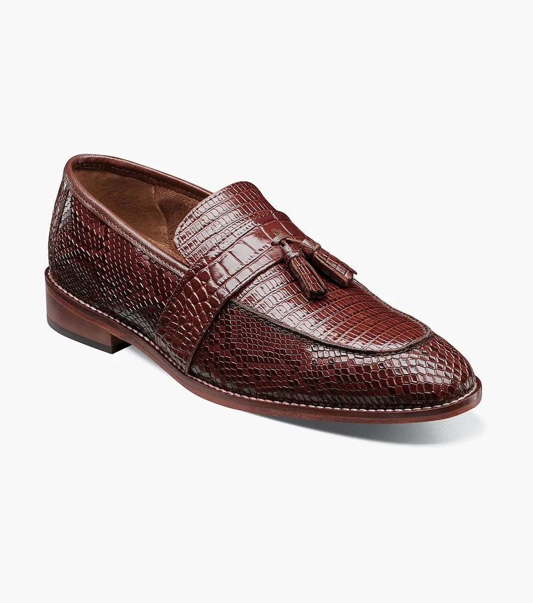 The Stacy Adams - PACETTI Leather Sole Moc Toe Tassel Slip On in Cognac, featuring a textured pattern with tassels on the front and a comfortable memory foam insole, is displayed against a plain white background.