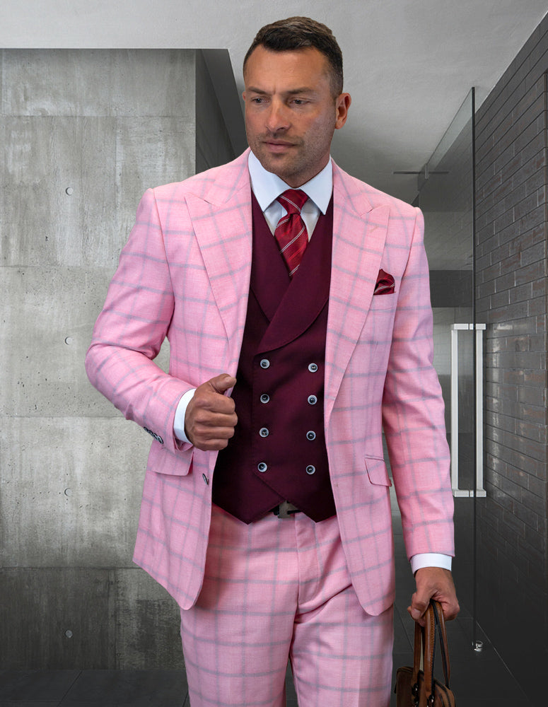 Dressed in a STATEMENT CLOTHING | PHILY-PINK ensemble from Statement Clothing, the man stands in a modern room, holding a brown bag.