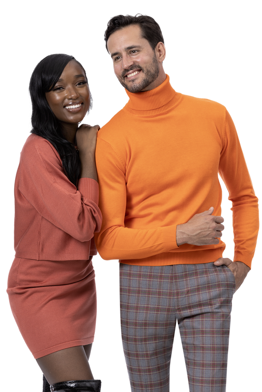 Two people smiling; one dressed in a peach outfit and the other showcasing a modern look with an orange turtleneck paired with stylish EJ Samuel Charc/Wine Plaid Pants PL103.