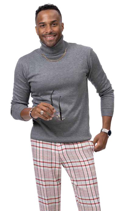 A smiling person in a gray turtleneck sweater and EJ Samuel Burgundy Plaid Pants PL121 holds glasses, standing against a white background.