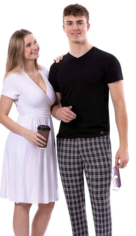 A woman in a white dress holds a coffee cup, standing next to a man wearing an EJ SAMUEL black shirt and EJ Samuel Black Plaid Pants PL134, casually holding sunglasses.