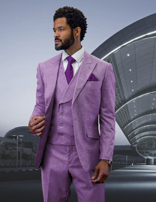 A man in the STATEMENT CLOTHING | RIMA-LAVENDER suit by Statement Clothing, featuring a peak lapel and double-breasted vest, stands in front of a modern, curved architectural structure.