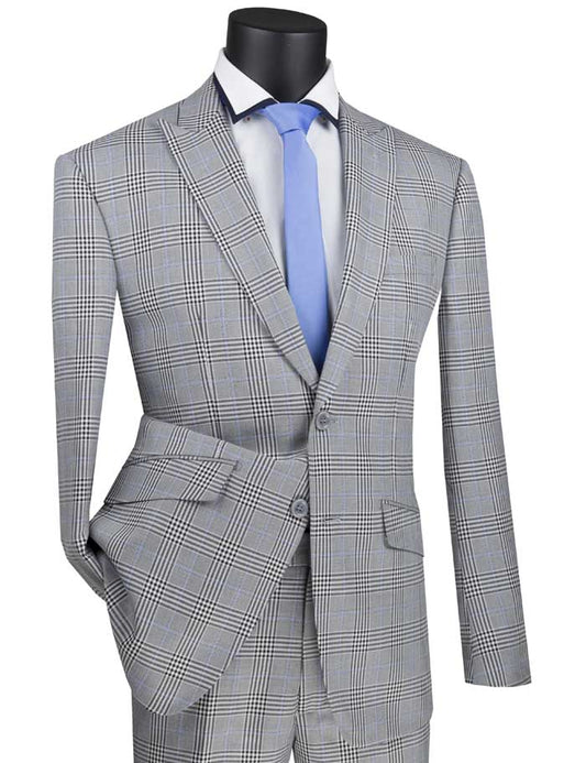 A stylish Vinci Slim Fit Suit with a peak lapel is adorned on a mannequin, elegantly complemented by a blue tie and crisp white shirt.