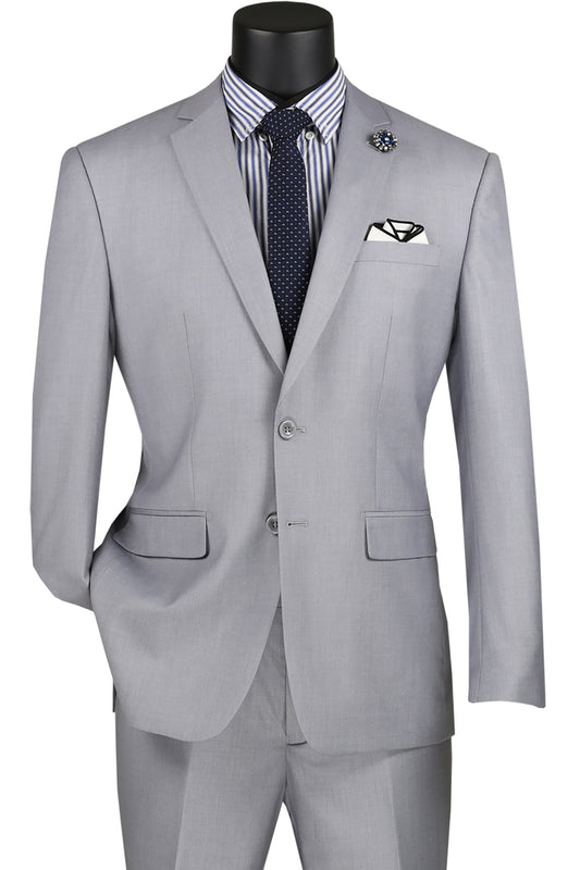 The Vinci Slim Fit 2 Piece 2 Button Suit in light gray from Vinci Suits is showcased with a stylish striped shirt and polka dot tie, complemented by a patterned pocket square and lapel pin. This wrinkle-resistant ensemble effortlessly combines classic elegance with modern flair.