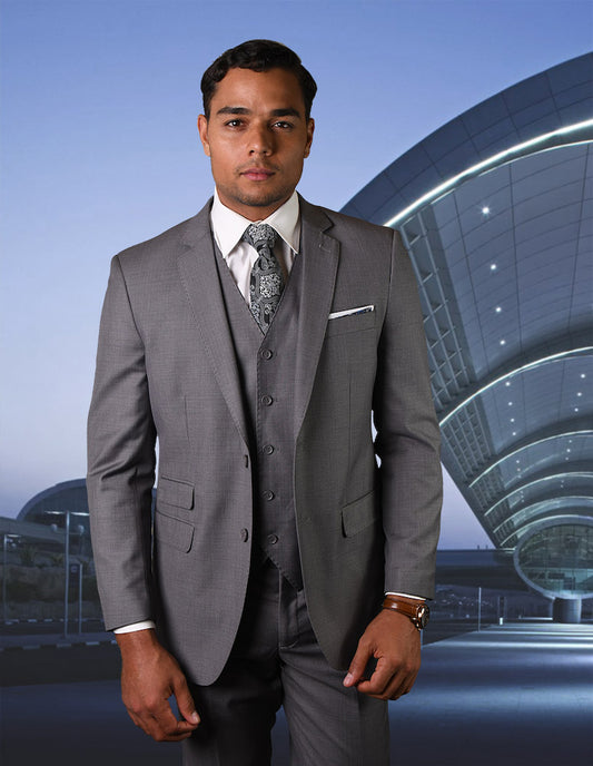 Wearing Statement Clothing's STATEMENT CLOTHING | STZV-101-GRAY, a well-dressed man stands confidently before a modern, curved architectural marvel. The clear sky accentuates the sophisticated appeal of his SUPER 180'S suit.