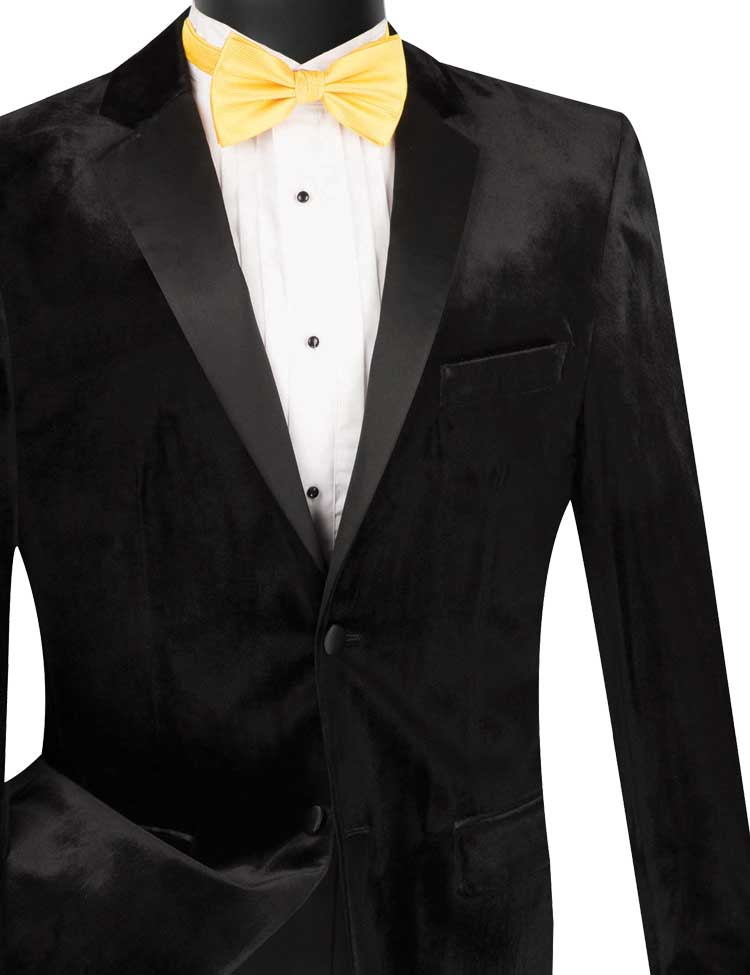 A mannequin showcases the Vinci Suits Vinci Slim Fit 2 Piece Velvet Tuxedo in black, featuring satin lapels, complemented by a crisp white shirt and a striking yellow bow tie. This ensemble is finished with single-breasted styling and sophisticated wool-blend pants, radiating timeless elegance.