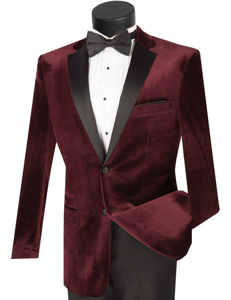 The Vinci Slim Fit 2 Piece Velvet Tuxedo in Wine by Vinci Suits, featuring a jacket with black lapels and a matching bow tie, pairs elegantly with a crisp white dress shirt, creating a sophisticated ensemble.