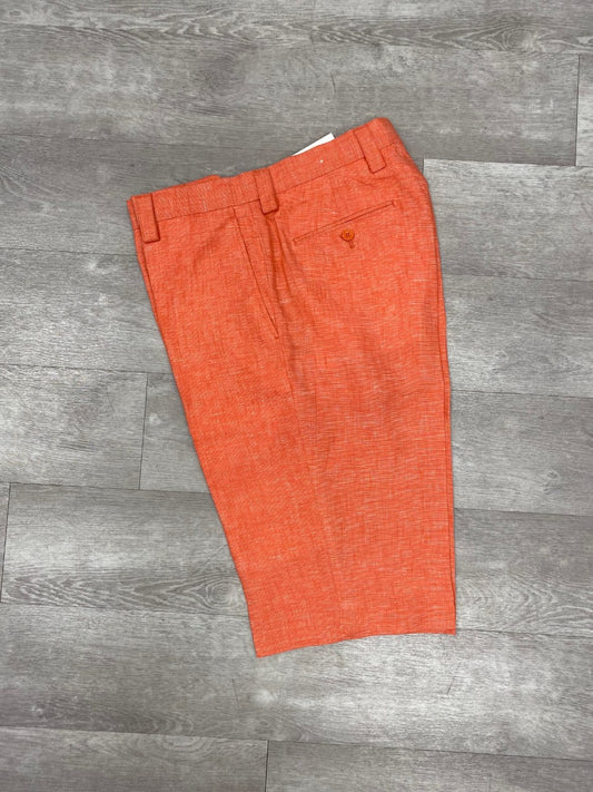 A pair of Inserch Premium Linen Flat Front Shorts in Tangy Orange, reminiscent of vibrant summer wardrobes, lies elegantly on a wood floor.