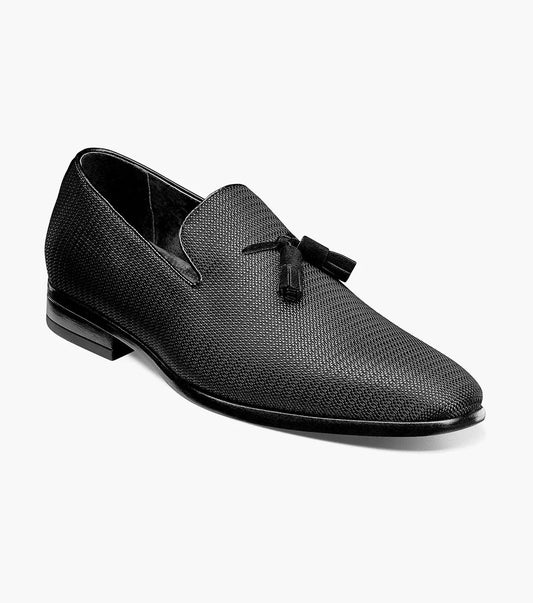 The Stacy Adams TAZEWELL Plain Toe Tassel Slip On in black, style number 25343-001, showcases a textured design with tassel detailing and includes a cushioned footbed, presented against a white background.