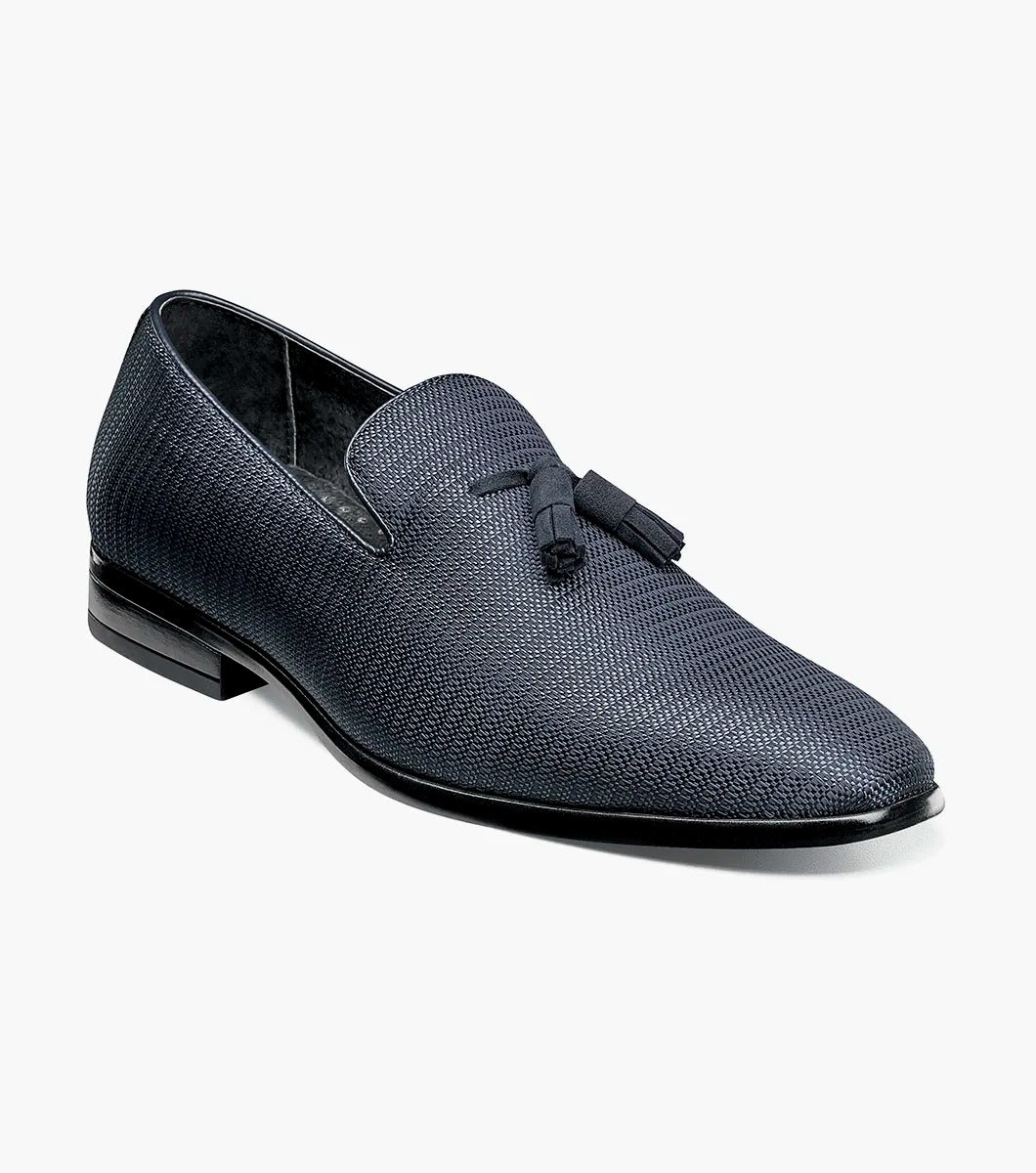 Here's a revised version of the sentence using the provided product data:

A single navy Stacy Adams TAZEWELL Plain Toe Tassel Slip-On loafer, identified by its tassel detail and textured finish, viewed from the side. This loafer features a low heel, sleek design, and cushioned footbed for added comfort.