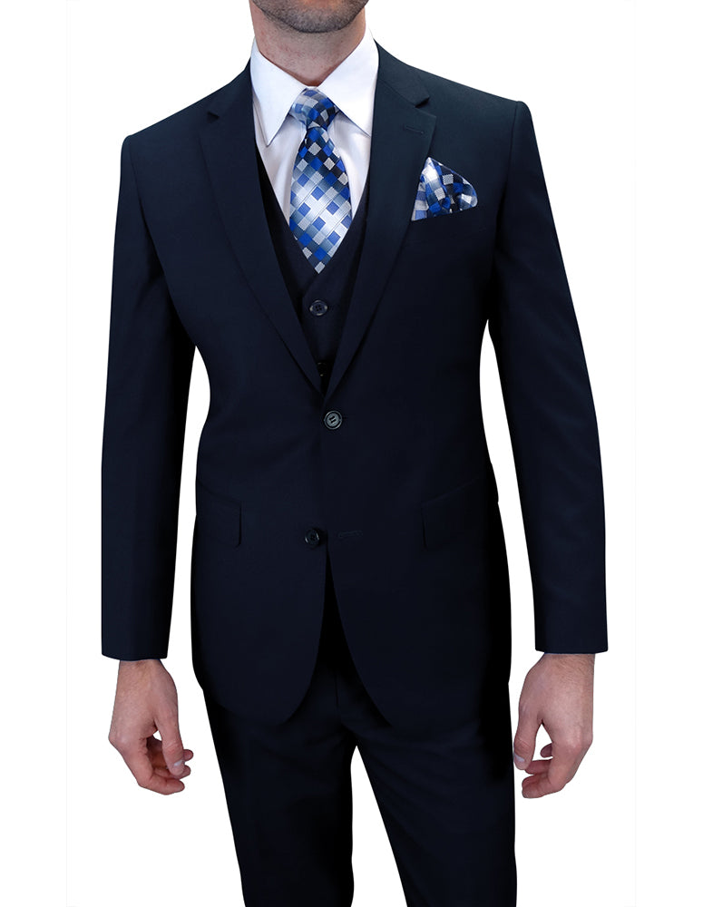 Man dressed in a Statement Clothing tailored fit suit, style TS-2V-NAVY made from Italian wool, paired with a blue and white patterned tie and pocket square, standing with hands by his sides.