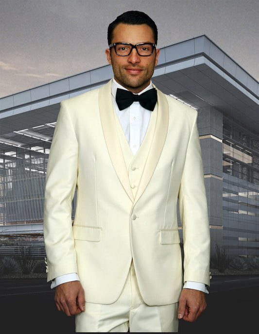 A man wearing the STATEMENT CLOTHING | TUX-SH-OFFWHITE from Statement Clothing, complete with a black bow tie, stands in front of a modern building, highlighting the elegance of its tailored fit and sleek shawl lapel design.