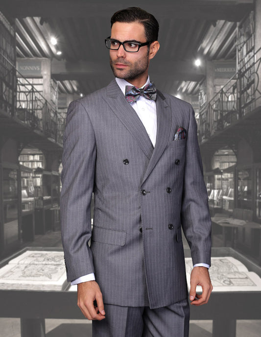 A man wearing the STATEMENT CLOTHING | TZD-300-CHARCOAL from Statement Clothing, a double-breasted pinstripe suit made from exquisite Italian fabric, paired with a bow tie, stands against a library backdrop, gazing to the side.