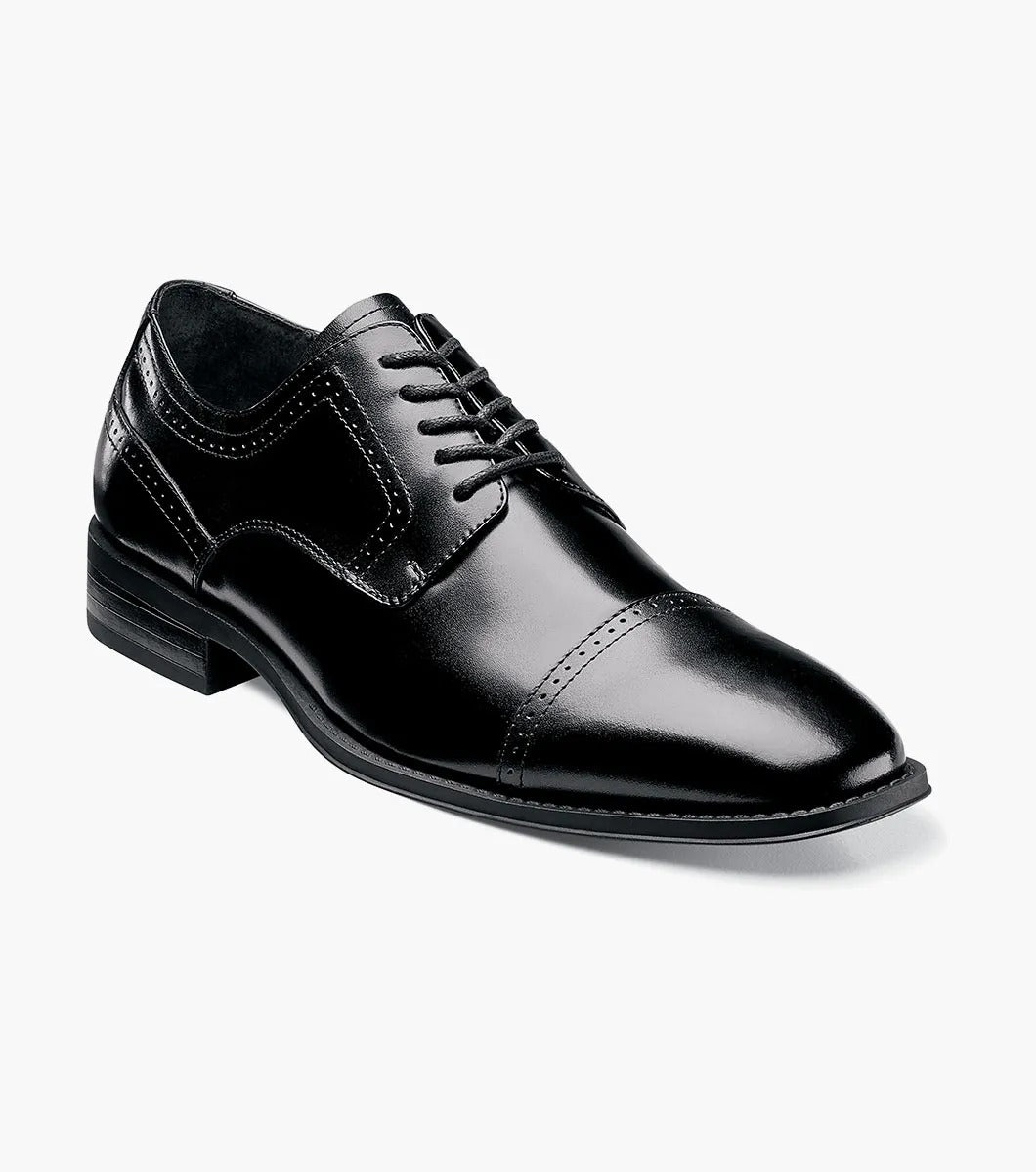 The Stacy Adams WALTHAM Cap Toe Oxford in black (model 20138-001) is a stylish leather dress shoe featuring laces, a sleek cap toe design, and elegant decorative stitching. The low heel and dress style rubber sole ensure modern comfort while maintaining timeless sophistication.