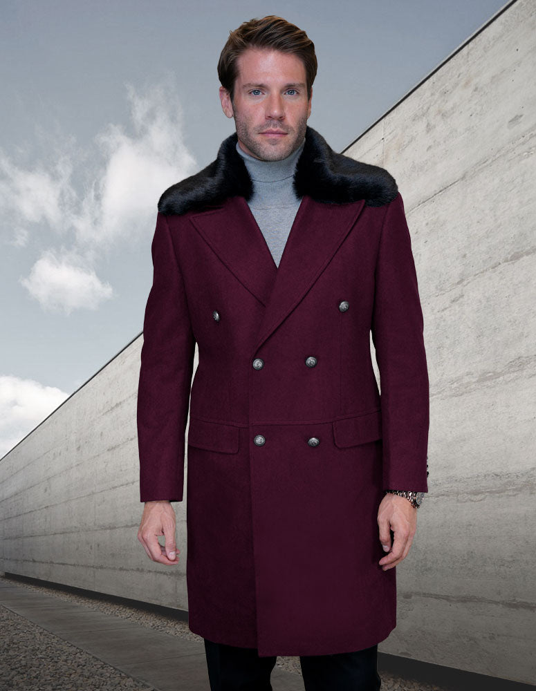 A person wearing the Statement Clothing WJ-102-BURGUNDY, a burgundy wool jacket with a black fur collar, stands outdoors against a cloudy sky and beige concrete wall.