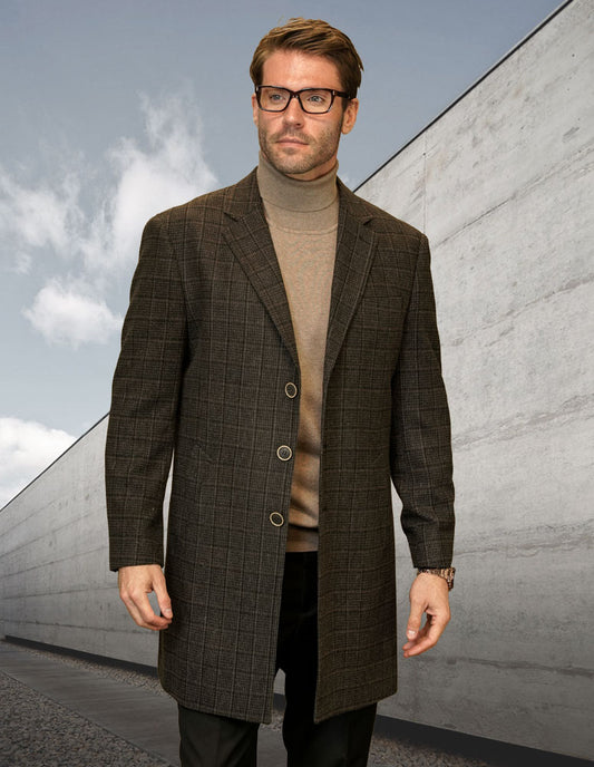 A man wearing the STATEMENT CLOTHING | WJ-103-BROWN modern fit plaid jacket from Statement Clothing and glasses stands on a concrete path with a cloudy sky in the background.