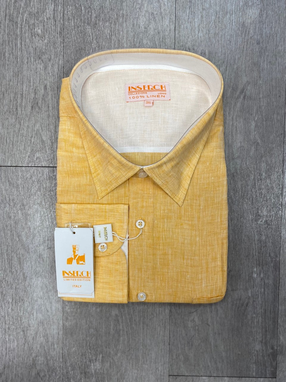 Inserch's Premium Linen Yarn-Dye Solid Long Sleeve Shirt (24116-16 Yellow) with tags, featuring subtle contrast trimming, is neatly folded on a wooden surface.