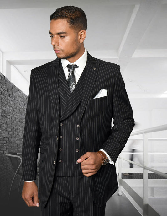 A man wearing the ZARELLI-BLACK suit from Statement Clothing stands confidently in a modern office interior. Complete with a double-breasted vest and pleated pants, his tie and pocket square add a touch of elegance to his regular fit ensemble.