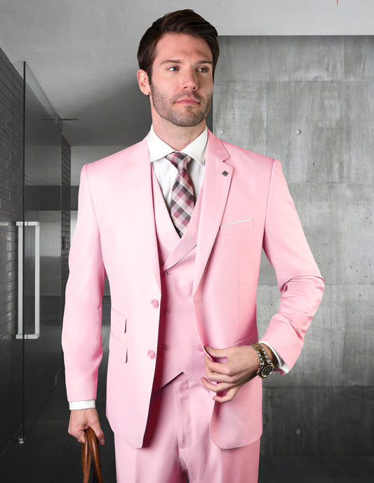 A man wearing the STATEMENT CLOTHING | ZARGALA-PINK ensemble, complemented by an Italian wool double-breasted vest, stands in a modern hallway.