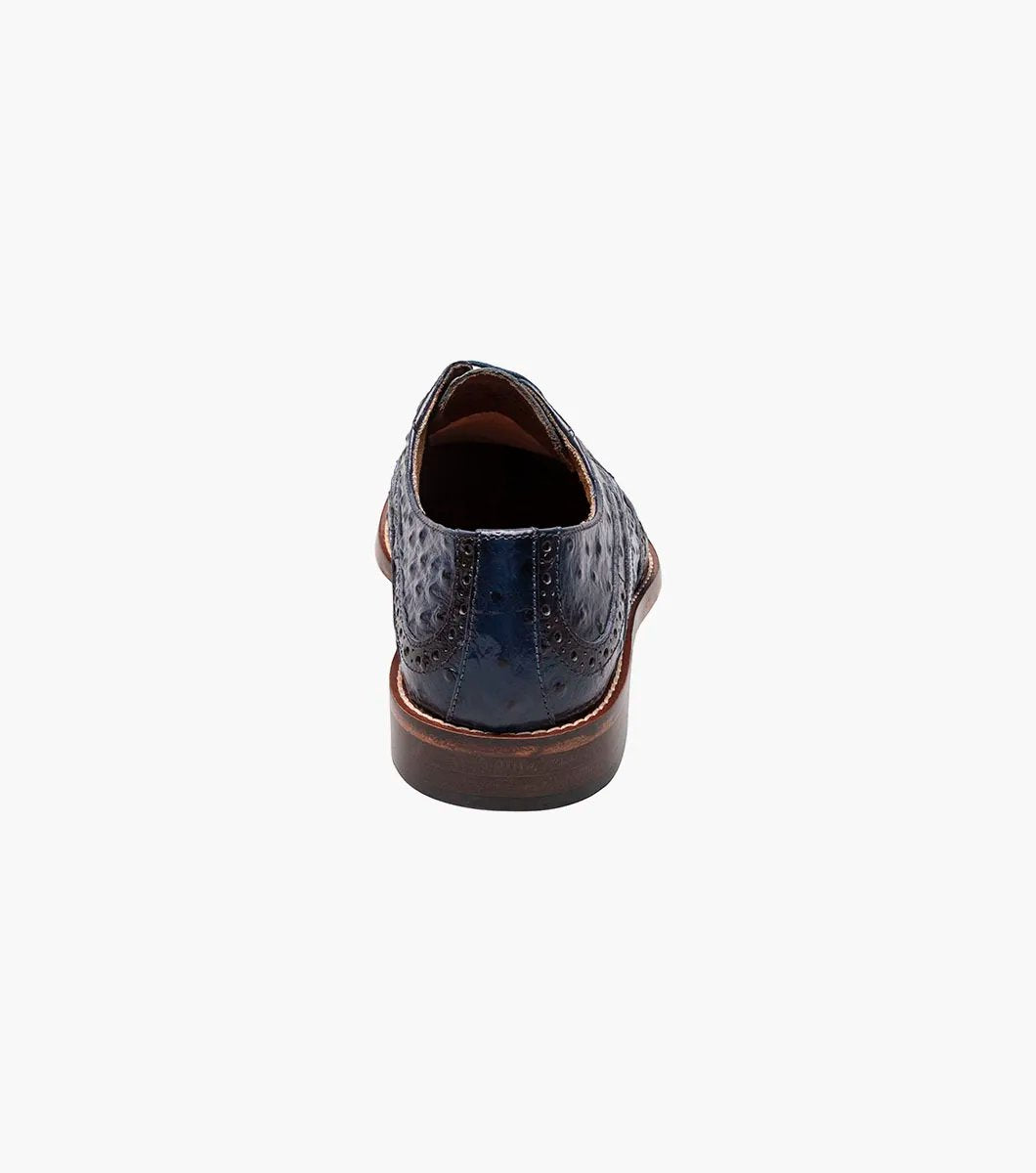 This blue Stacy Adams Gennaro Wingtip Oxford, featuring a textured ostrich quill print finish and a brown sole, elegantly captures the refined style associated with the Stacy Adams brand.