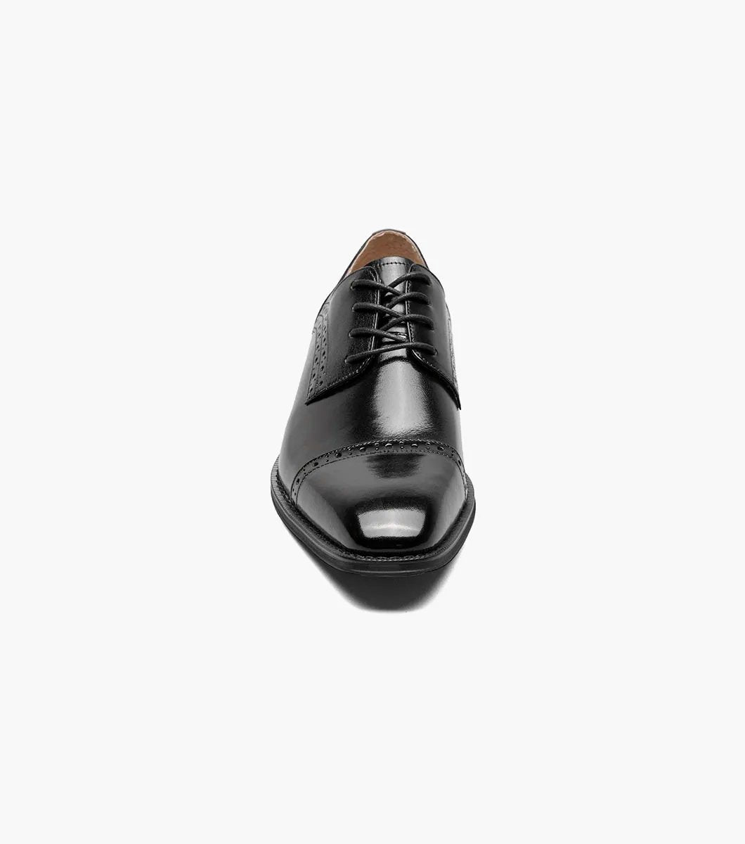 A Stacy Adams - GARRETT Cap Toe Oxford shoe in black leather, featuring decorative perforations, laces, and a luxurious Memory Foam insole, is shown on a white background.